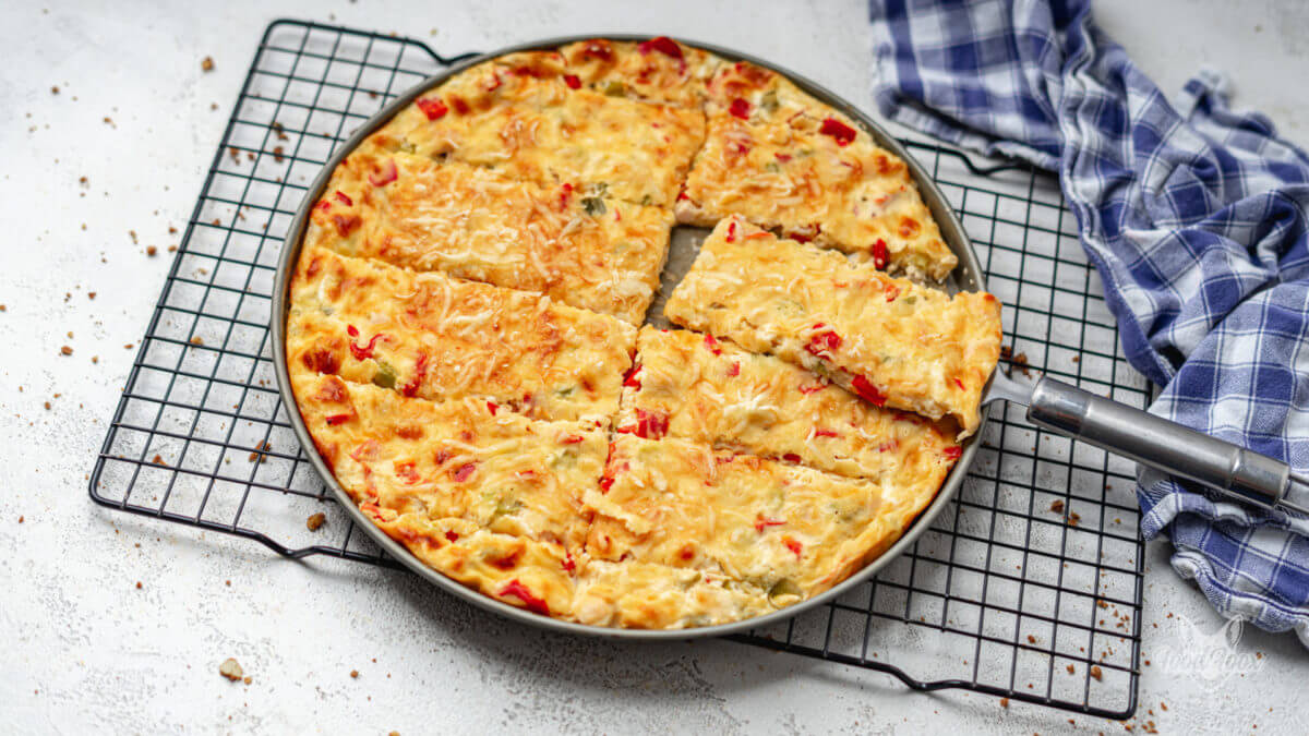 knusprige Low Carb Schüttelpizza mit Paprika und Hähnchen vom rundem Pizzablech. n Streifen geschnitten. Ein Stück liegt wird herausgenommen.