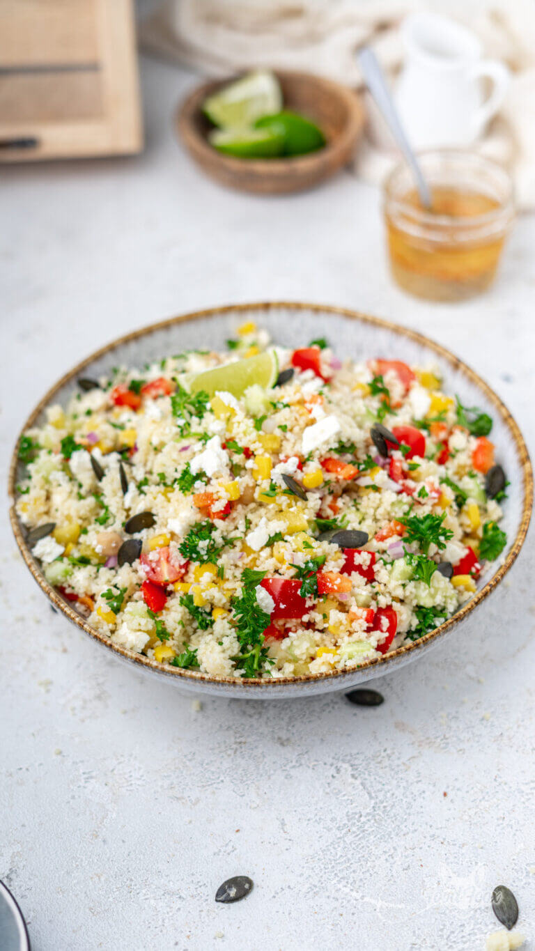 einfacher & schneller Couscous Salat mit Feta, Kichererbsen und Gurke. Angerichtet in einem tiefen Teller. Garniert mit Kernen.