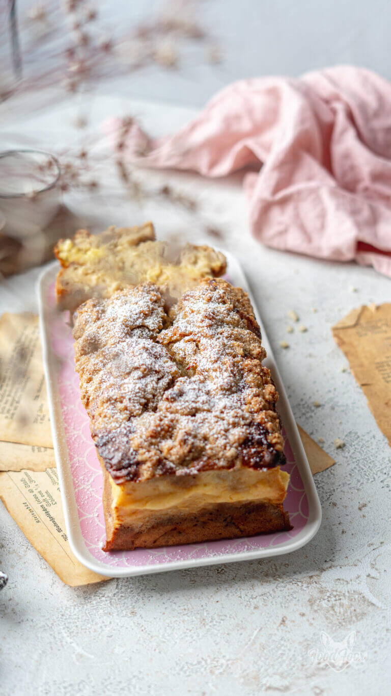 Detailsaufnahme des gesundenBananebrotes auf einem Kuchenteller. Die Streusel wurden mit Puderzucker verziert.