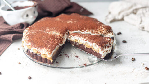 Anschnitt einer Tiramisu Brownie Torte mit fluffiger Creme und saftigem Boden. Das Innere sieht unwiderstehlich lecker aus.